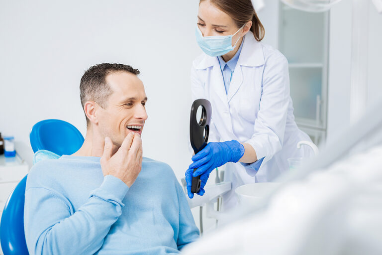 A dentist talking with a patient in Calgary, AB.